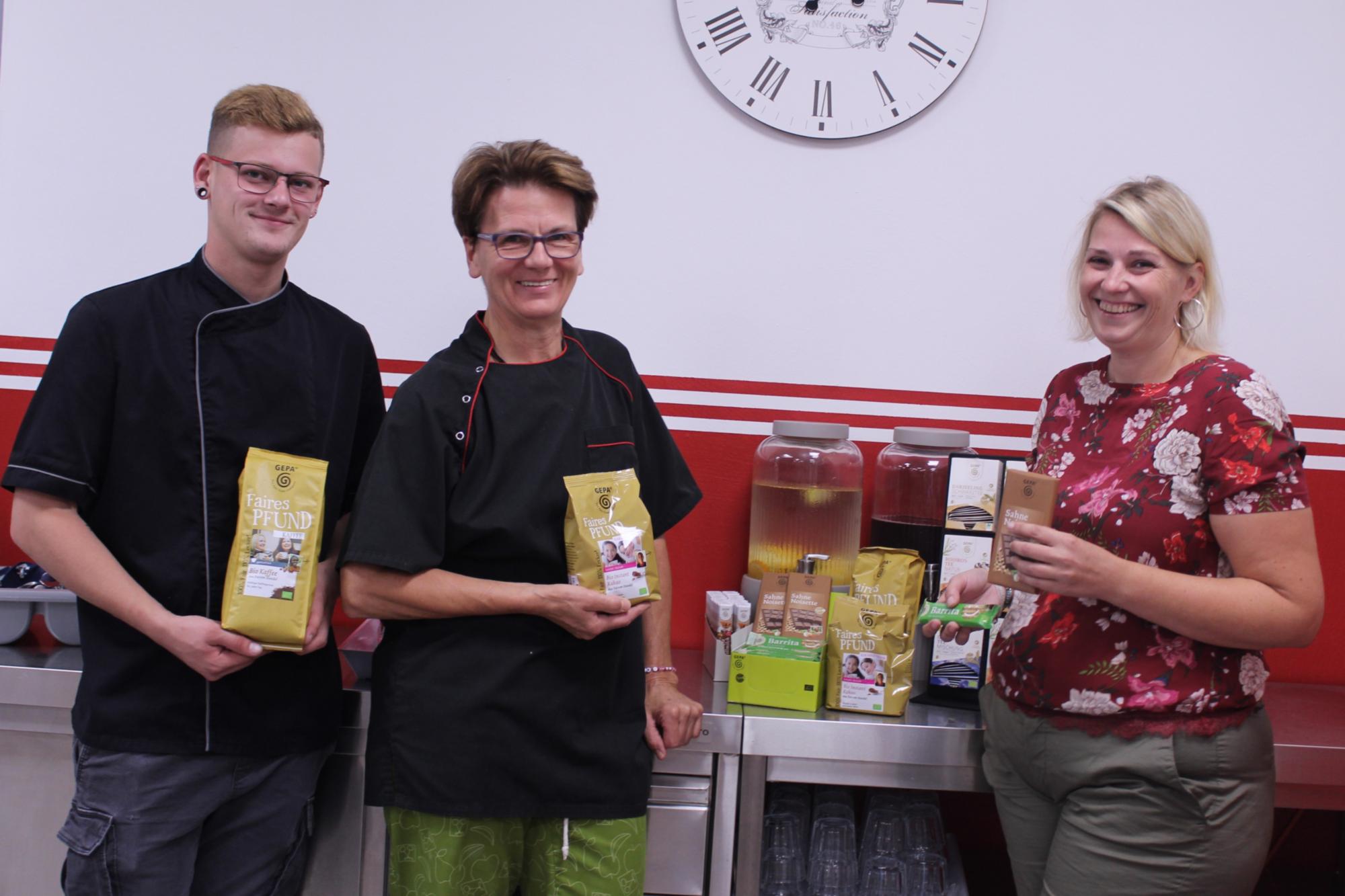 Stephanie Wollgarten (Hausleitung), Ursula Justen (Küchenleitung) und Nico Baales (Mitarbeiter Küche) präsentieren das Fairtrade-Angebot der Jugendstätte Rursee.